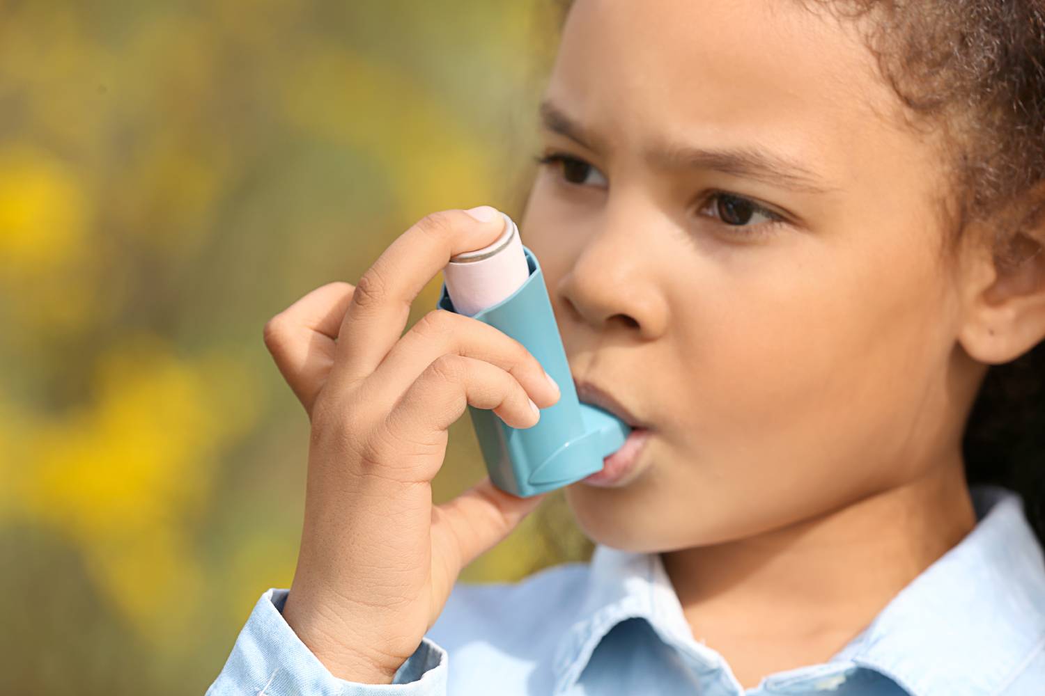African-American girl with inhaler having asthma attack